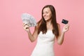 Smiling bride woman in lace white wedding dress holding bundle lots of dollars, cash money and credit card on Royalty Free Stock Photo
