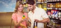 Smiling bright couple buying food products with shopping basket Royalty Free Stock Photo