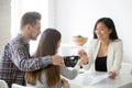 Smiling broker giving keys from first house to millennial couple Royalty Free Stock Photo