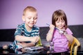 Smiling brother and sister with water colors, coloring Easter eggs Royalty Free Stock Photo