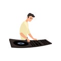 Smiling disk jockey standing sideways plays on turntable on white background