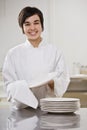 Smiling brunette drying dishes.