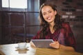 Smiling brunette having coffee and holding tablet Royalty Free Stock Photo