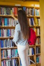 Smiling brunette student picking out book Royalty Free Stock Photo