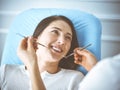 Smiling brunette woman being examined by dentist at dental clinic. Hands of a doctor holding dental instruments near Royalty Free Stock Photo