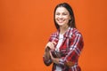 Smiling brunette woman in eyeglasses and casual posing with crossed arms and looking at the camera over orange background Royalty Free Stock Photo