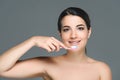 smiling brunette woman holding tooth brush in hand