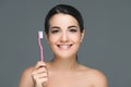 smiling brunette woman holding tooth brush in hand