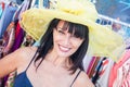 Smiling Brunette Woman Modeling a Big Sun Hat at the Market