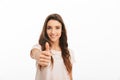 Smiling brunette woman in t-shirt showing thumb up at camera Royalty Free Stock Photo