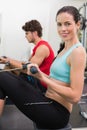Smiling brunette working out on the rowing machine Royalty Free Stock Photo