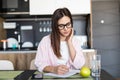 Smiling woman writing on note pad in the kitchen Royalty Free Stock Photo