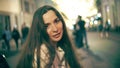 Smiling brunette young woman on illuminated pedestrian street background