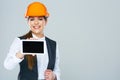 Smiling builder business woman showing tablet PC with yours inf