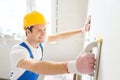 Smiling builder with grinding tool indoors