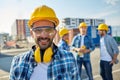 Smiling builder with hardhat and headphones