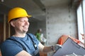 Smiling builder holding clipboard and write down needed work material for renovation