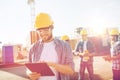 Smiling builders in hardhats with tablet pc