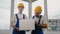 Smiling builders wearing hardhats showing blank board. Royalty Free Stock Photo