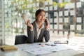 Smiling business asian woman in talking consultant on mobile phone at modern office Royalty Free Stock Photo