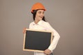 Smiling business builder woman with board, portrait on gray. Woman worker builder hold sign board blank. Building Royalty Free Stock Photo