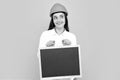 Smiling business builder woman with board, portrait on gray. Woman worker builder hold sign board blank. Building Royalty Free Stock Photo