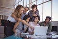 Smiling business colleagues discussing over laptop at office Royalty Free Stock Photo