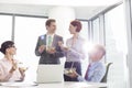 Smiling business colleagues eating lunch in boardroom during meeting at office Royalty Free Stock Photo