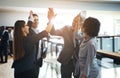 Smiling business colleagues high fiving each other in an office Royalty Free Stock Photo