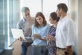 Smiling business colleagues using mobile phone, digital tablet and laptop Royalty Free Stock Photo