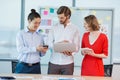 Smiling business colleagues using mobile phone, digital tablet and laptop Royalty Free Stock Photo