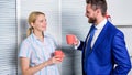 Smiling business couple at office room talking in coffee break. Business and people concept. Work culture. Royalty Free Stock Photo