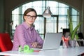 Smiling Business Lady in casual clothing sitting at Office Table Royalty Free Stock Photo