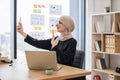 Assistant joining online meeting via phone at office desk