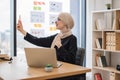 Assistant joining online meeting via phone at office desk