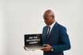 Smiling business man holding laptop with question Royalty Free Stock Photo