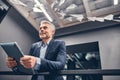 Smiling business man holding laptop while standing at the corridor Royalty Free Stock Photo