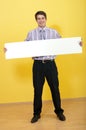 Smiling business man holding wide blank white card Royalty Free Stock Photo
