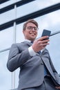 Smiling business man reading SMS on his smartphone Royalty Free Stock Photo