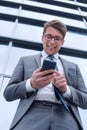 Smiling business man reading SMS on his smartphone Royalty Free Stock Photo