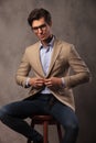 Smiling business man sitting and unbuttoning his coat Royalty Free Stock Photo