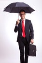 Smiling business man under an umbrella walking Royalty Free Stock Photo