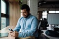 Smiling business man using mobile phone while sitting in office Royalty Free Stock Photo