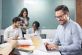 Smiling business man working on laptop in the office Royalty Free Stock Photo