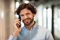 Smiling business man working and talking on phone at office Royalty Free Stock Photo