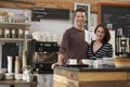 Smiling business owners behind the counter of their cafe Royalty Free Stock Photo