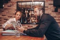 Smiling business partners, young man and woman sitting in cafe, talking positively and using a digital tablet Royalty Free Stock Photo