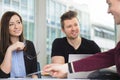 Smiling Business People Looking At Colleague Explaining At Desk Royalty Free Stock Photo