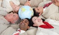 Smiling business people lying around a globe Royalty Free Stock Photo