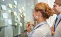 Smiling business people with marker and stickers Royalty Free Stock Photo